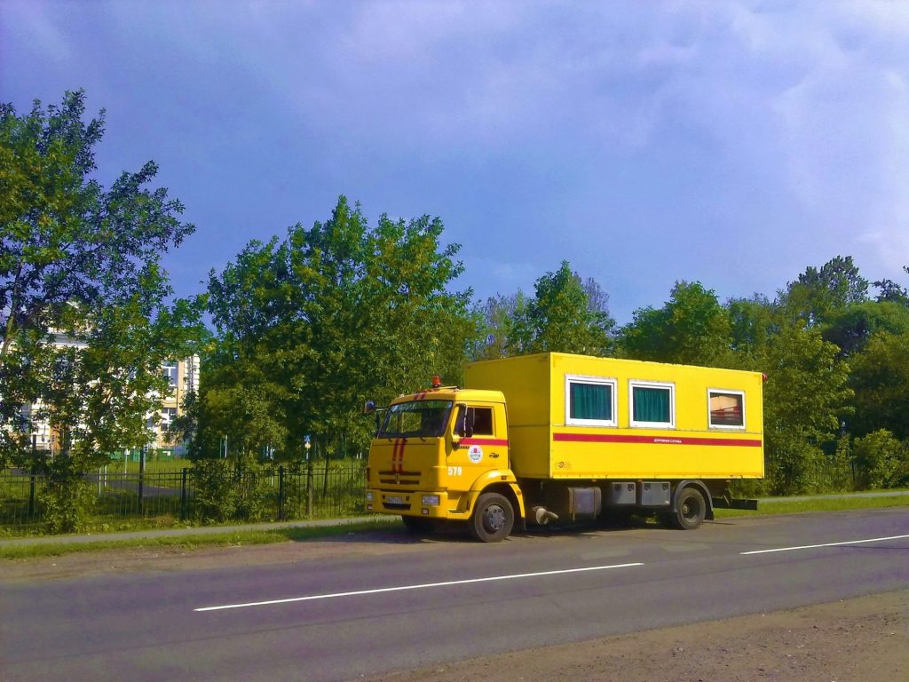 Ein gelber Lastwagen fährt eine Straße entlang.