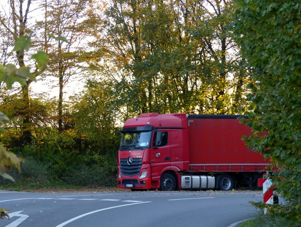 ein roter LKW steht am Straßenrand